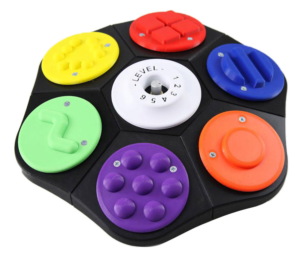 A large round communicator on a Lazy Susan base with six brightly colored pie-slice plates, each bearing a raised tactile design.