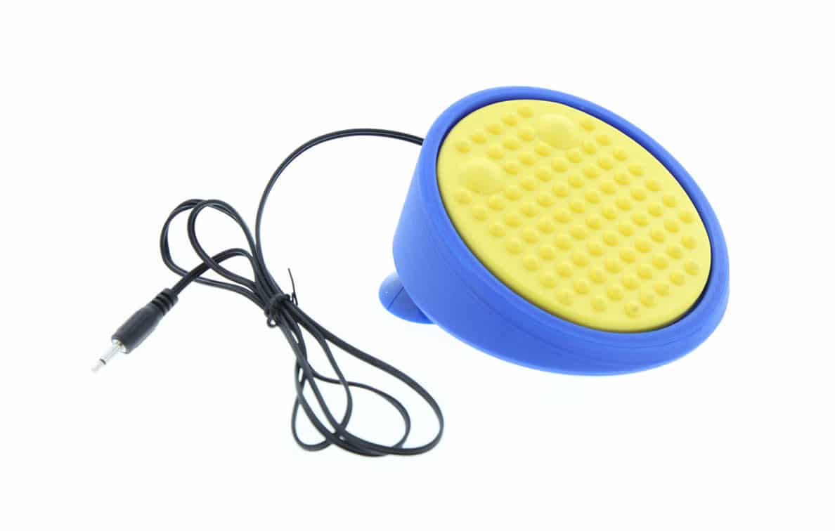 An oval-shaped switch with a textured top surface and a cable, mounted on suction cups.