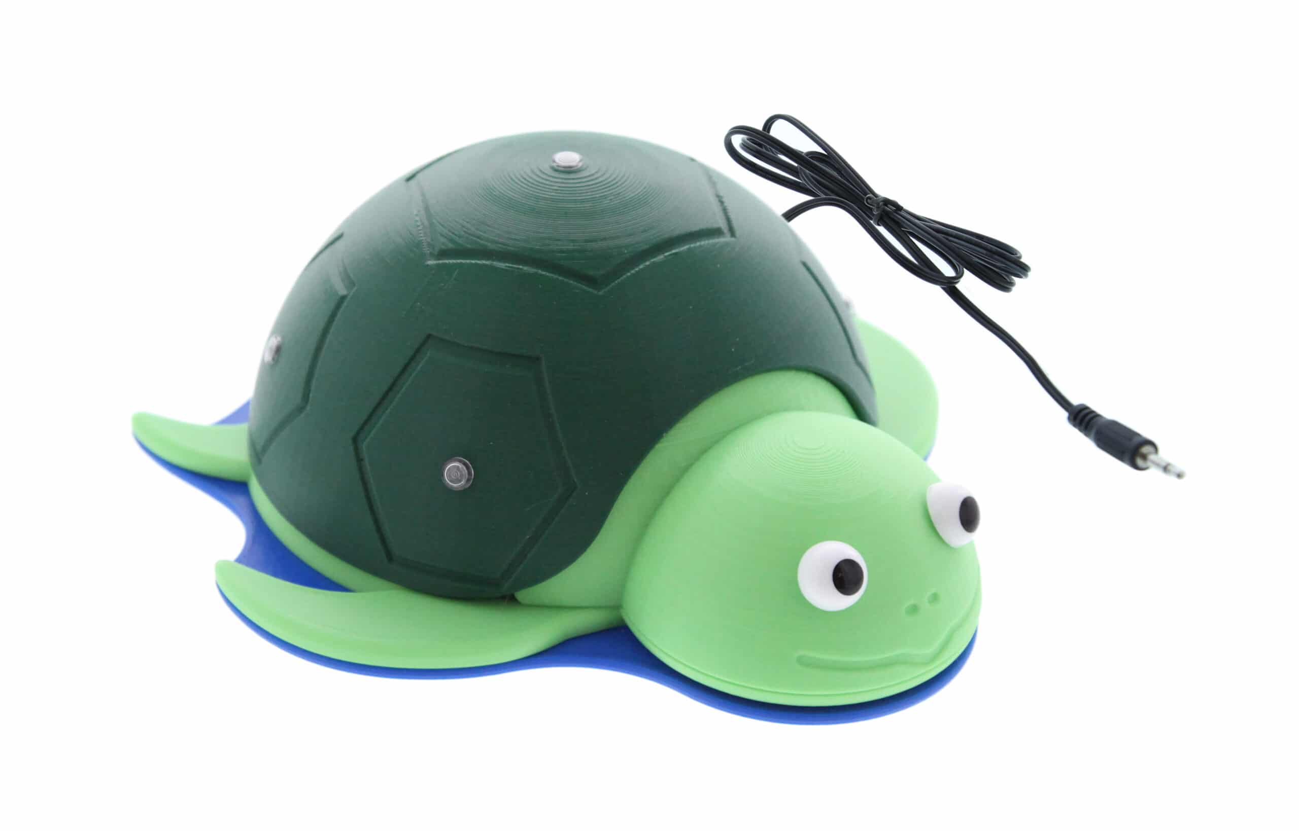 A green turtle-shaped switch toy with a domed shell that serves as the activation surface, with a connecting wire cable.