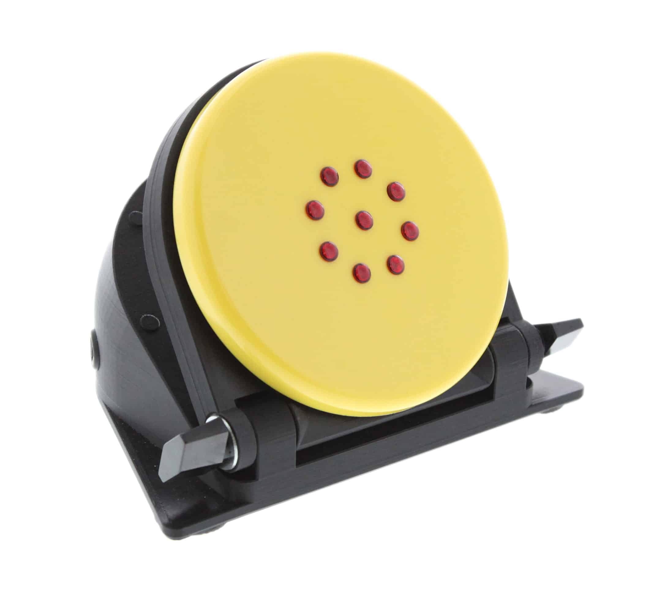 A wedge-shaped sequencer device with a large round button on its angled top face ringed by LED lights, mounted on an adjustable-angle base.