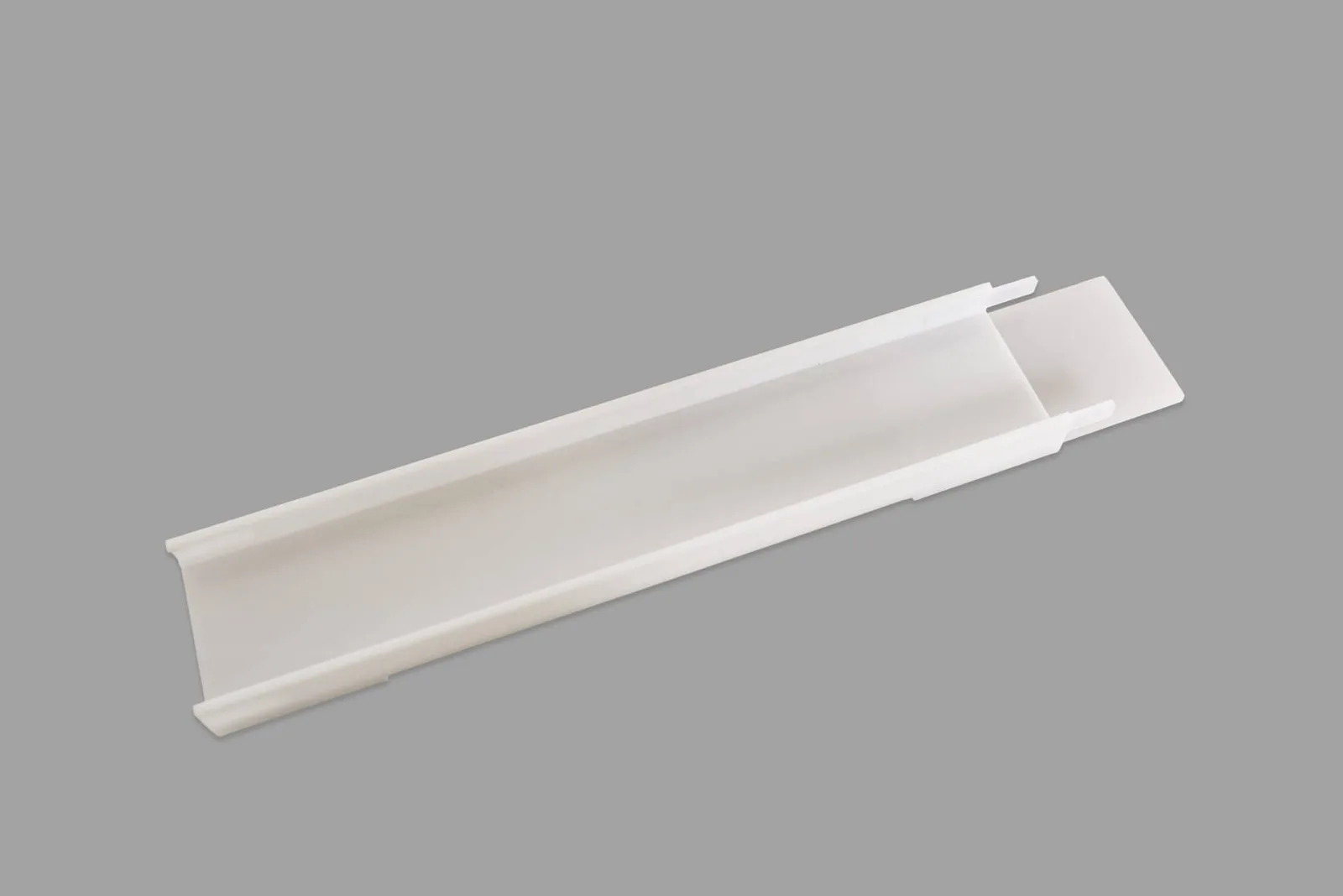 A short, clear polycarbonate ramp section with a channel and connector tabs.