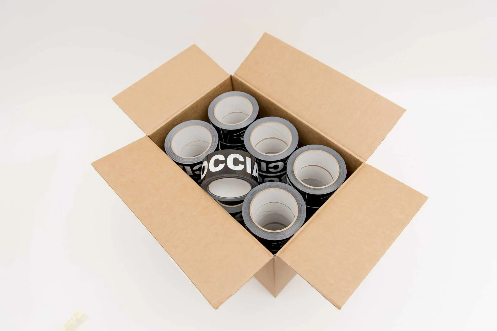 An open cardboard box filled with rolls of black boccia court tape.