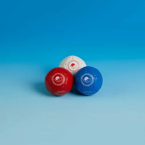 Three leather New Standard boccia balls in red, white and blue, stacked together.