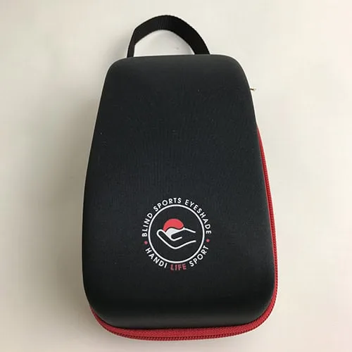 A black hard eyeshade case with a red zip, carry loop and the Blind Sports Eyeshade logo.