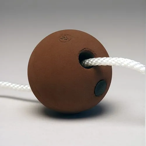 A small brown rubber sphere with a white rope threaded through a hole in its side.
